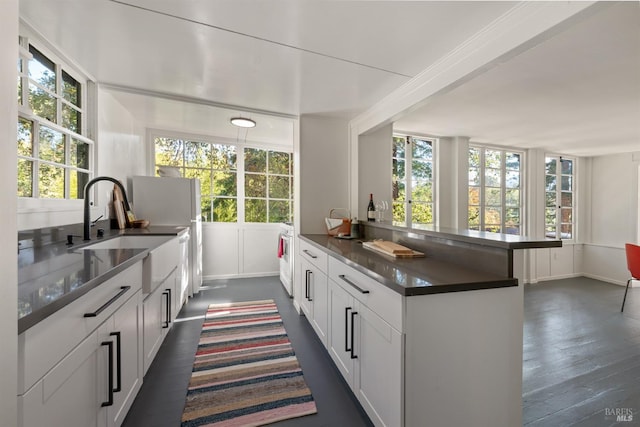 kitchen featuring sink, white cabinetry, an island with sink, and dark hardwood / wood-style floors