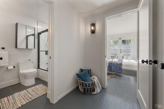 bathroom with wood-type flooring, french doors, toilet, and combined bath / shower with glass door