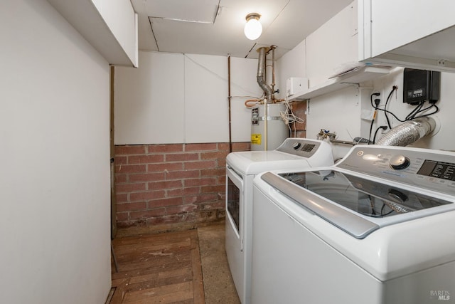 clothes washing area with separate washer and dryer and gas water heater