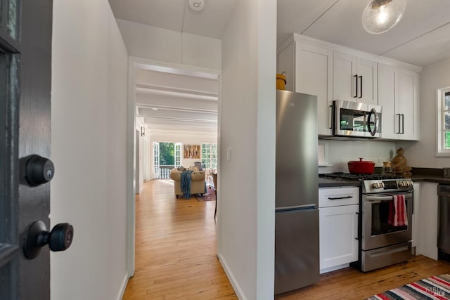 kitchen with light hardwood / wood-style floors, appliances with stainless steel finishes, and white cabinetry