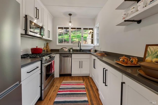 kitchen featuring sink, appliances with stainless steel finishes, hardwood / wood-style flooring, and white cabinets