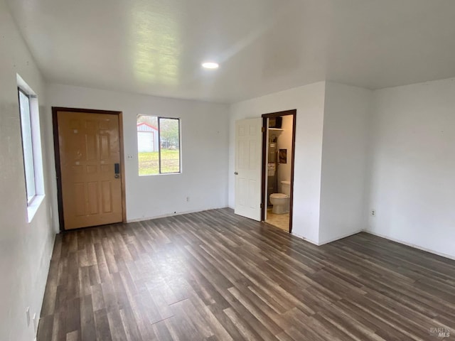 unfurnished bedroom featuring dark hardwood / wood-style floors and connected bathroom