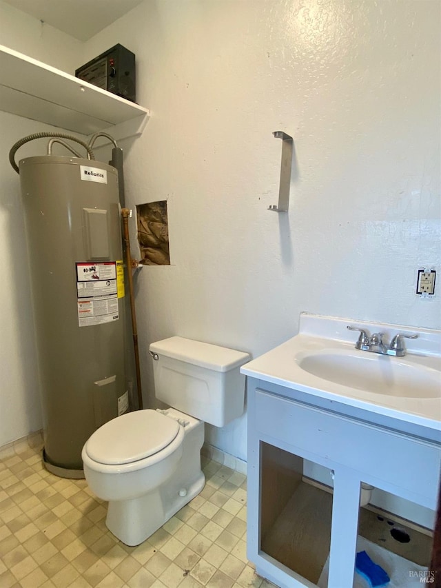 bathroom featuring vanity, electric water heater, tile patterned floors, and toilet