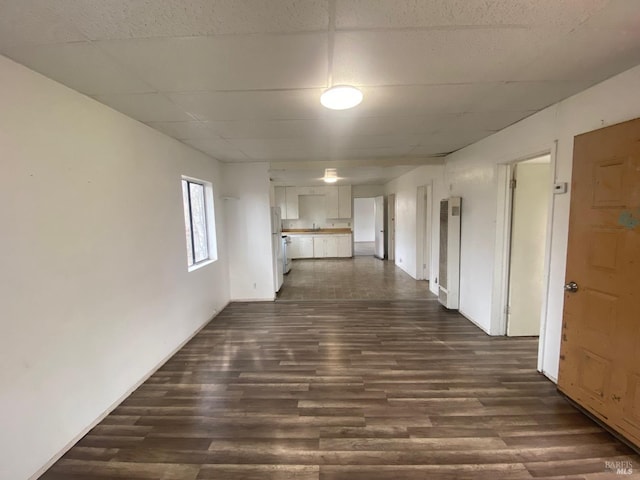 hallway featuring a drop ceiling and dark hardwood / wood-style flooring