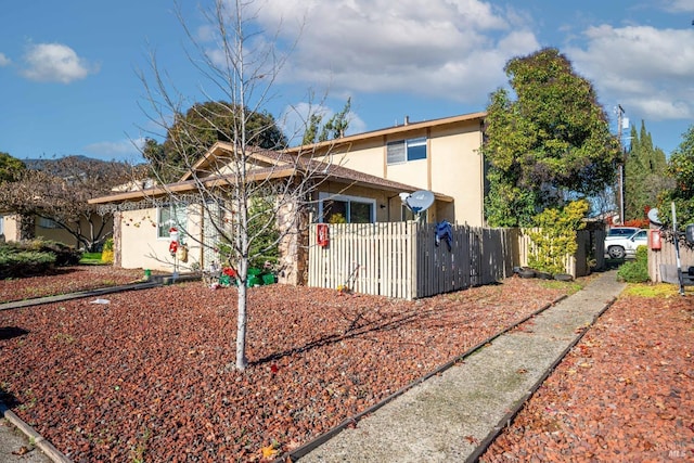 exterior space with stucco siding and fence