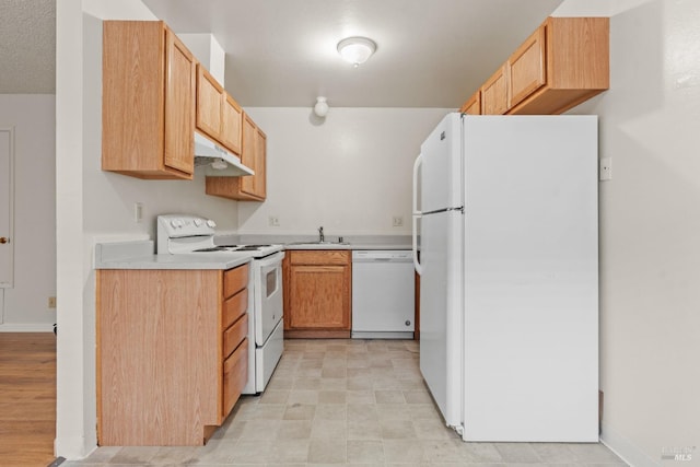 kitchen with light countertops, white appliances, baseboards, under cabinet range hood, and a sink