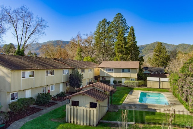 view of property's community featuring a yard, a mountain view, and a swimming pool