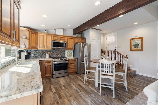 kitchen with stainless steel appliances, vaulted ceiling with beams, tasteful backsplash, dark wood-type flooring, and sink