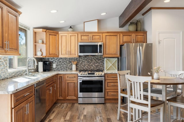 kitchen with stainless steel appliances, vaulted ceiling with beams, light stone countertops, backsplash, and dark hardwood / wood-style flooring