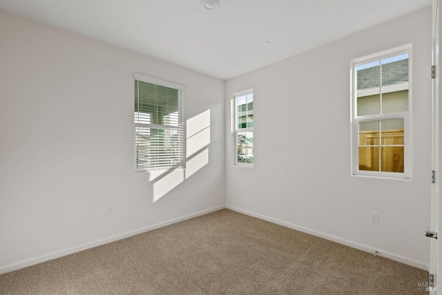 carpeted spare room featuring a wealth of natural light