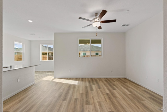 empty room with ceiling fan and light wood-type flooring
