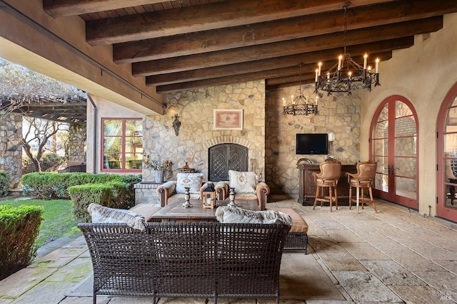 view of terrace featuring french doors and an outdoor stone fireplace