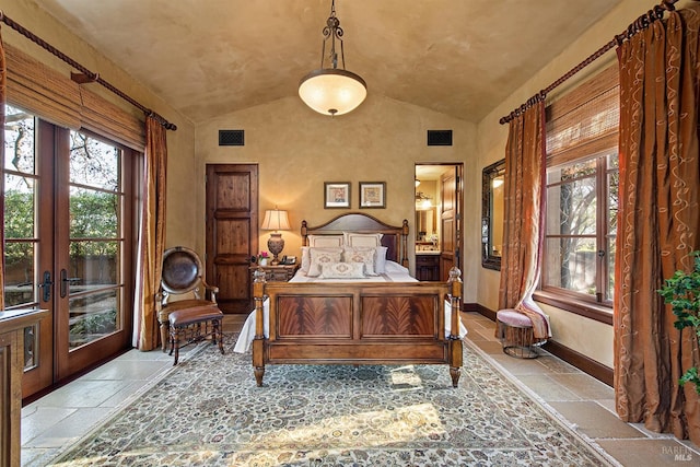 tiled bedroom featuring french doors, multiple windows, and lofted ceiling