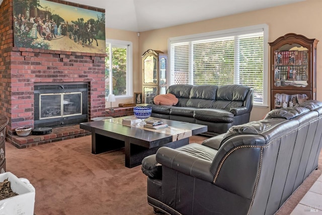 living room with a wealth of natural light, light carpet, vaulted ceiling, and a brick fireplace