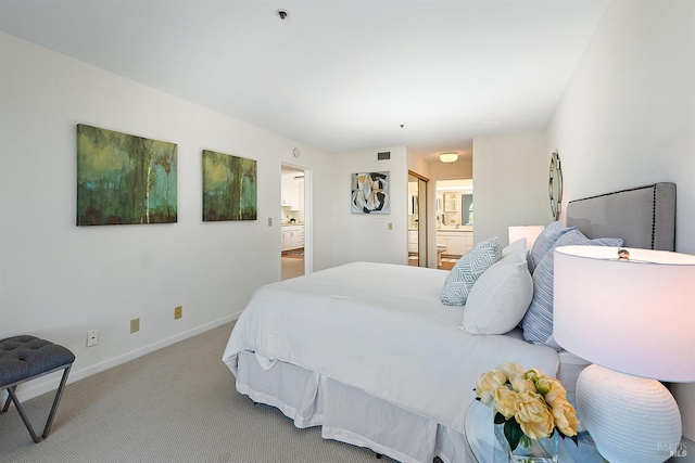 bedroom featuring connected bathroom and light colored carpet