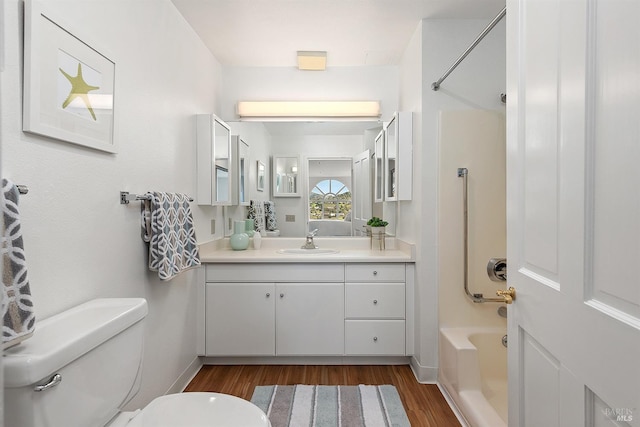 full bathroom featuring hardwood / wood-style flooring, vanity, bathing tub / shower combination, and toilet