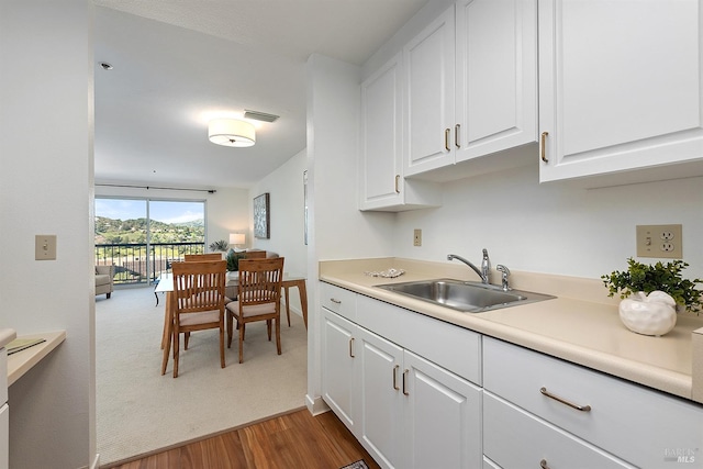 kitchen featuring sink, white cabinets, and hardwood / wood-style floors