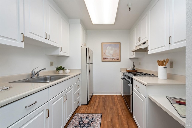 kitchen featuring refrigerator, sink, gas range, and white cabinets