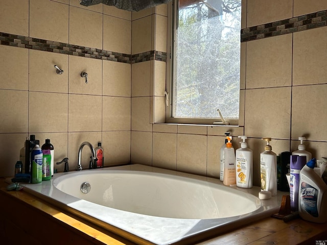 bathroom with a healthy amount of sunlight and tiled tub