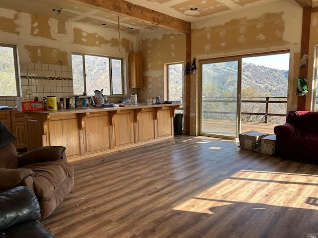 interior space featuring kitchen peninsula, a mountain view, a breakfast bar, and dark hardwood / wood-style floors