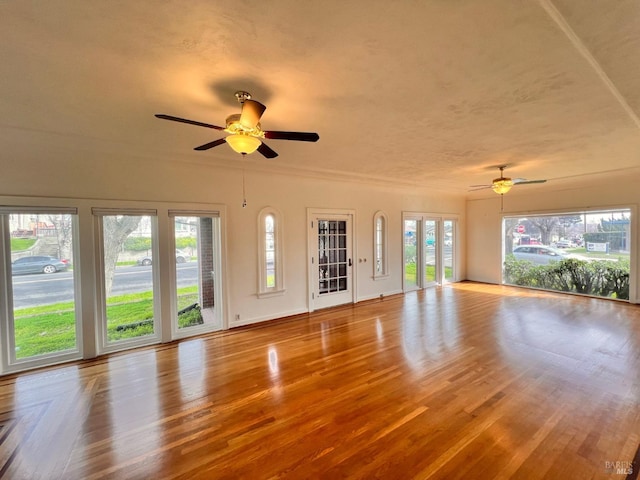 unfurnished living room with ceiling fan and plenty of natural light