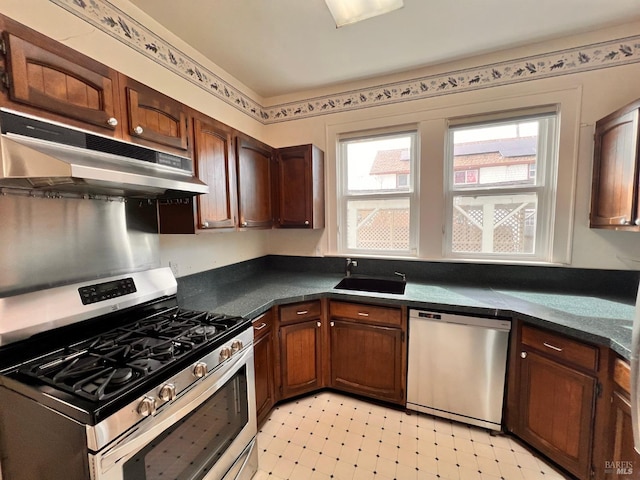 kitchen with dark brown cabinets, stainless steel appliances, light tile flooring, and sink