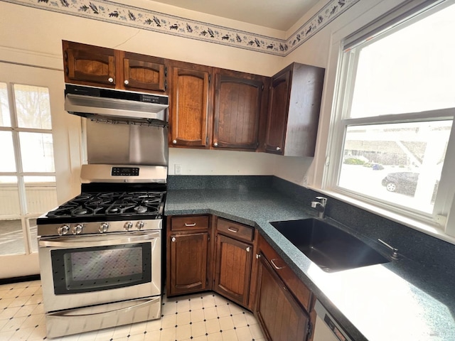 kitchen with light tile flooring, stainless steel gas stove, and a wealth of natural light