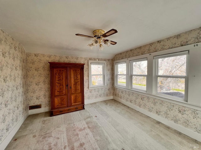 carpeted spare room featuring ceiling fan and lofted ceiling