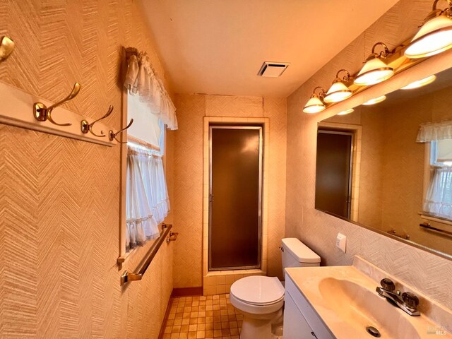 bathroom featuring tile walls, toilet, a shower with door, tile flooring, and vanity