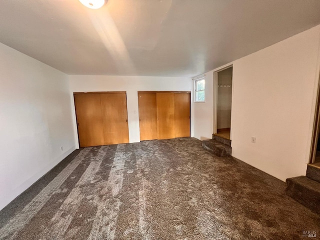 spare room featuring dark colored carpet