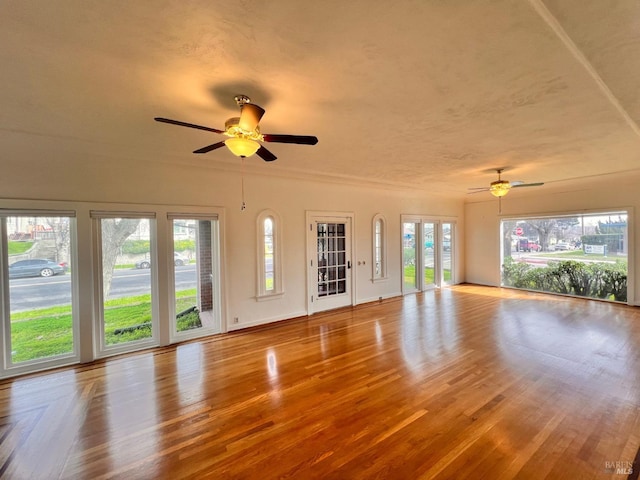 unfurnished living room with ceiling fan and light hardwood / wood-style flooring