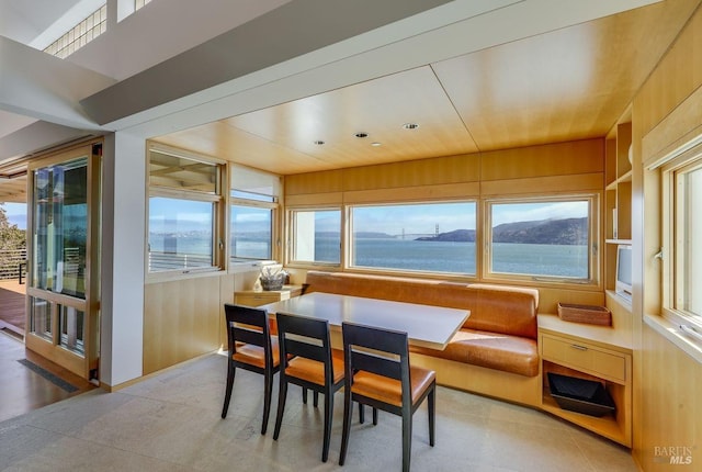 dining area with a water view and wood walls