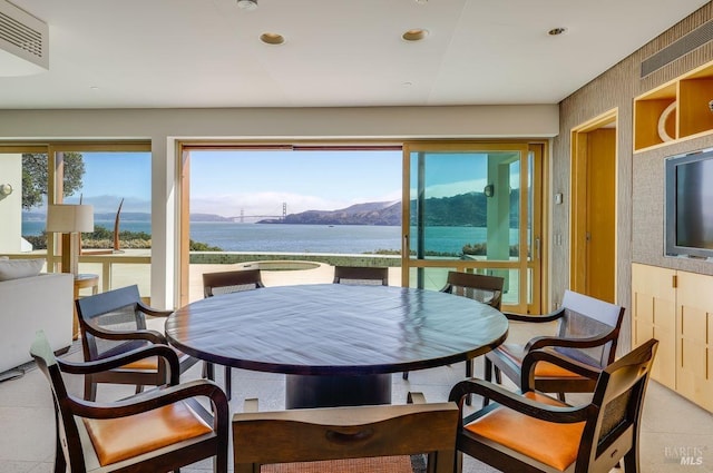 interior space featuring a water and mountain view and light tile floors