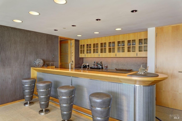 bar featuring light brown cabinets and light tile floors