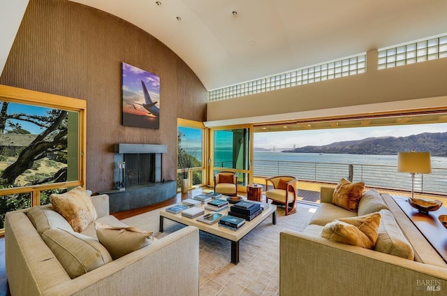 living room featuring high vaulted ceiling, plenty of natural light, and a water and mountain view