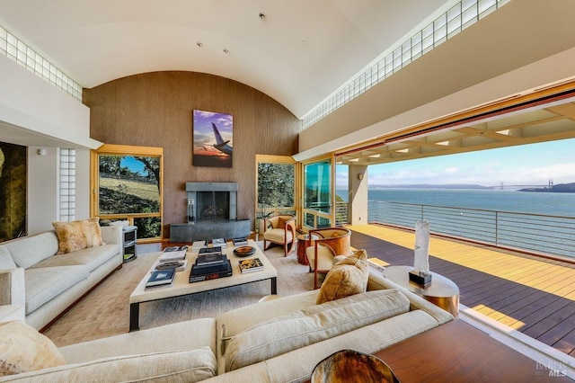 living room with high vaulted ceiling and a water view