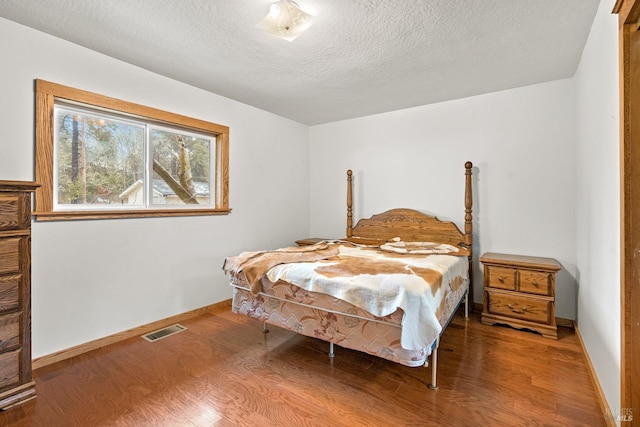 bedroom featuring a textured ceiling and hardwood / wood-style floors