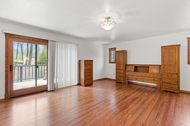 unfurnished living room with an inviting chandelier and hardwood / wood-style flooring