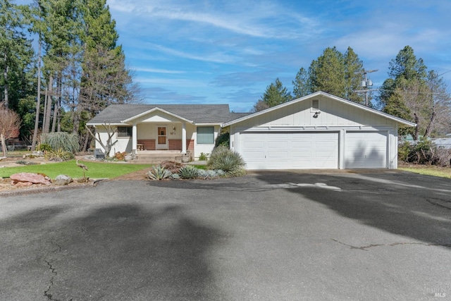 ranch-style house featuring a garage and covered porch