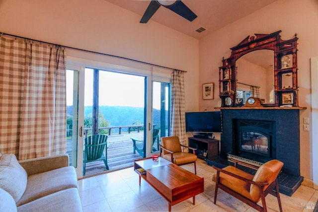 tiled living room featuring ceiling fan and a mountain view