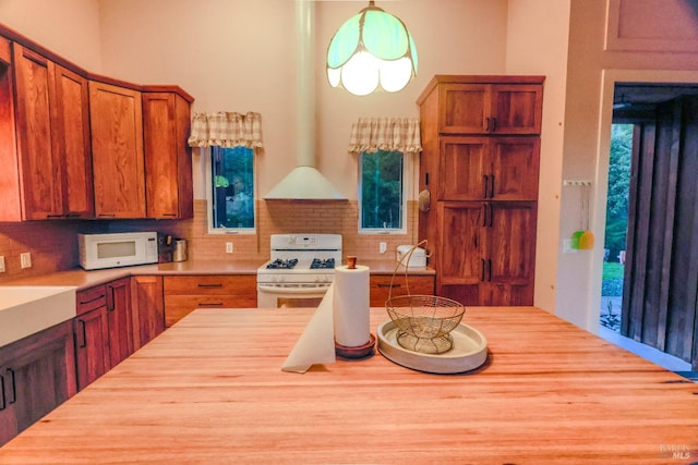 kitchen with white appliances, hanging light fixtures, and backsplash