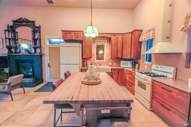 kitchen with wood counters, fume extractor, a center island, white appliances, and light tile flooring