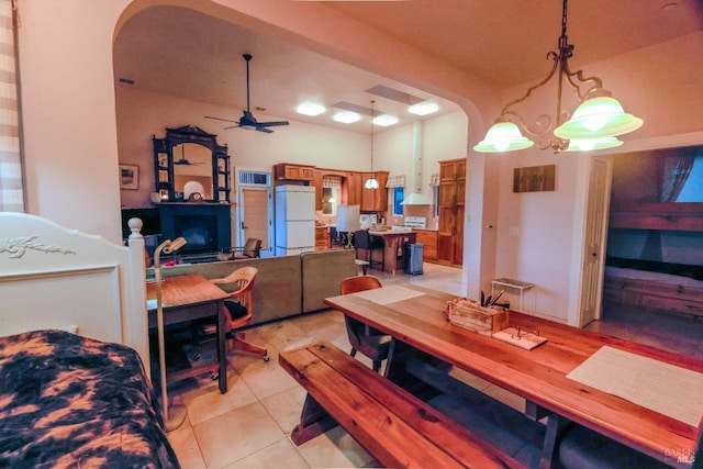 tiled dining room featuring ceiling fan with notable chandelier