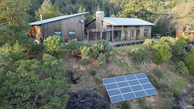 back of house featuring a deck and solar panels