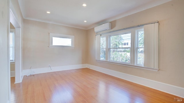 unfurnished room featuring light hardwood / wood-style floors and a wall mounted AC