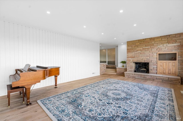 living room with light wood-type flooring and a stone fireplace