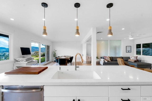 kitchen featuring plenty of natural light, hanging light fixtures, and sink