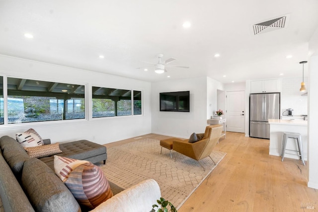 living room with light hardwood / wood-style floors and ceiling fan