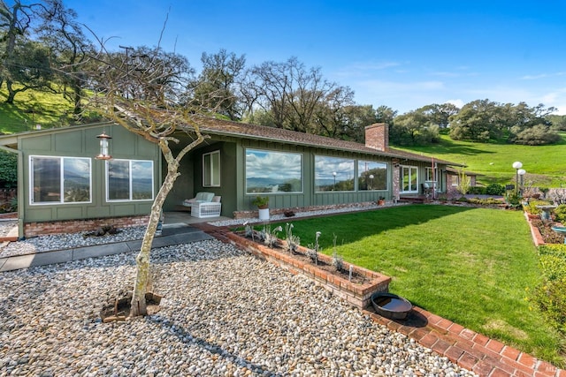 view of front of house featuring a front lawn and a patio area