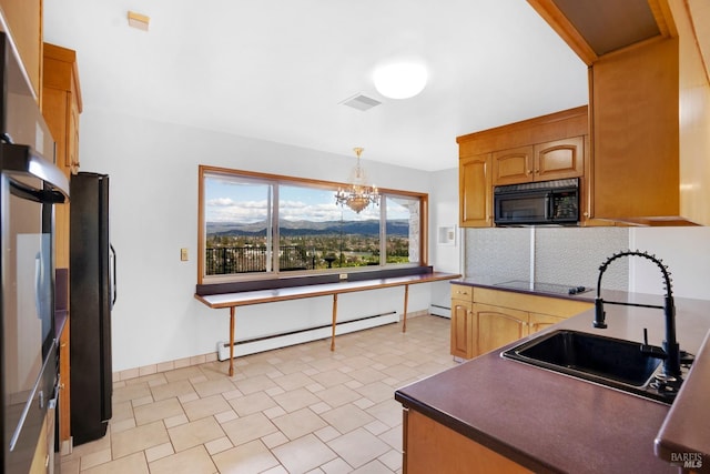 kitchen featuring black appliances, an inviting chandelier, a baseboard heating unit, light tile floors, and pendant lighting